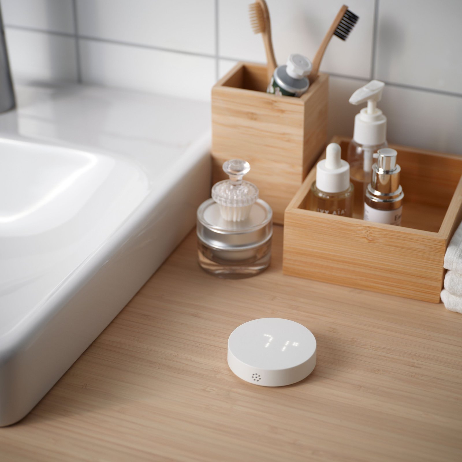 TIMMERFLOTTE temperature and humidity sensor from IKEA next to a bathroom sink