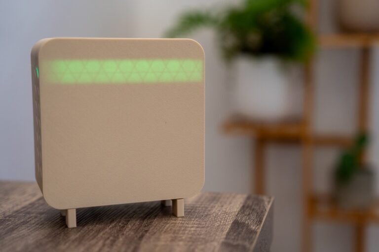 Beige Air Quality Sensor, sitting on bench, nice plant background